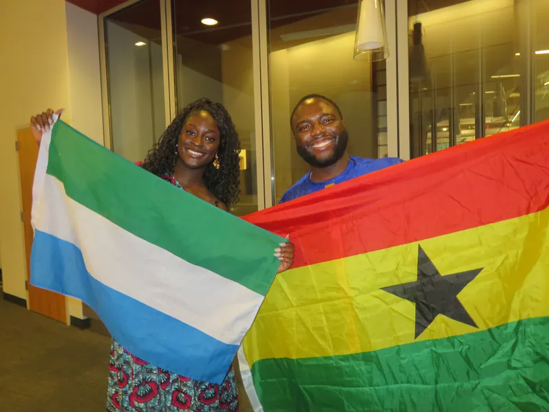 Friends holding Ghanaian flags